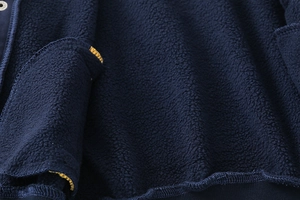 Detail of navy boy's baseball jacket with thick fleece lining and yellow stitching