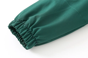 Detailed close-up of windproof elastic cuffs on dark green hooded jacket for boys