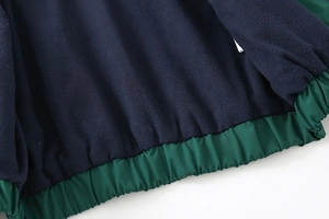 Macro view of children's jacket showing navy fleece lining and elastic hem detail