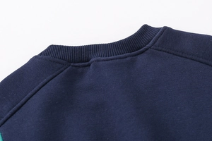 Detail of the crew neck ribbed collar and raglan sleeve stitching on the navy toddler sweatshirt