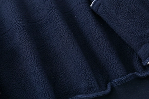 Macro detail of thick navy fleece lining and high-quality overlock stitching on kids jacket