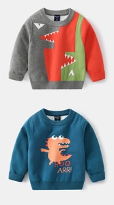 Detail view of two dinosaur themed knitted sweaters for kids with ribbed crew neck design