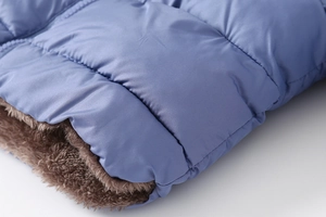Detail of blue quilted fabric with soft brown faux fur lining on warm kids jacket