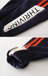 Close-up of boys thick winter pants showing orange stripes and warm fleece lining