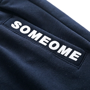 Close-up of SOMEOME letter print on navy blue knit fabric with white screen printing