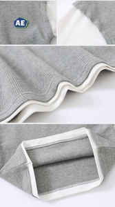 Détails du tissu gaufré gris avec écusson logo et coutures contrastées aux manches