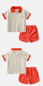 Vue détaillée du polo gris avec col orange et short assorti pour enfants en coton