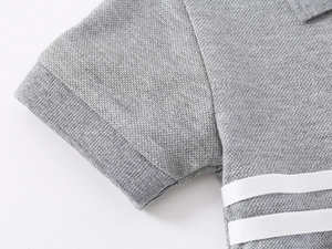 Detail of grey piqué cotton polo shirt featuring white horizontal stripes on chest