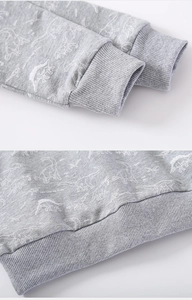 Close-up of ribbed cuffs and dinosaur print on grey knitted sweatshirt for kids