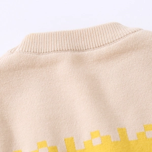 Detail of ribbed crew neck and woven geometric pattern on beige kids knit sweater