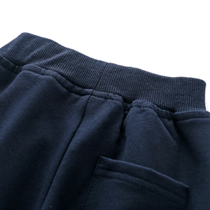 Detail of navy blue kids knit joggers with ribbed elastic waistband and back pocket