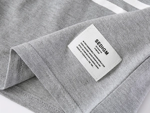 Detail of gray cotton pique polo shirt showing a stitched label and quality seam work