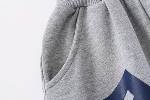 Gros plan du pantalon de sport gris clair pour garçon avec taille côtelée et poche latérale