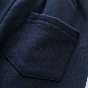 Detail of navy knit fabric showing reinforced double stitching and patch pocket quality