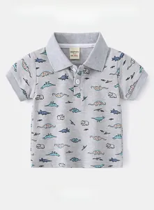 Detail of boys' polo shirt showing breathable piqué cotton fabric and dinosaur prints