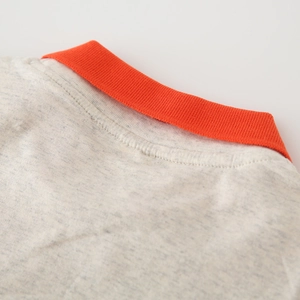Détail du polo pour enfant en tissu gris chiné avec un col côtelé orange vif