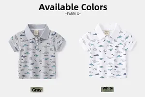 Detail view of cotton polo shirts with cute cartoon dinosaur prints in grey and white