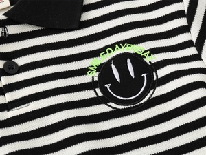 Close-up of smile embroidery on striped cotton polo shirt with ribbed lapel collar