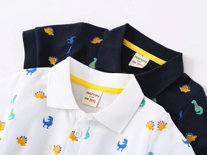 Detail of baby polo shirts with colorful dinosaur prints and yellow neck tape