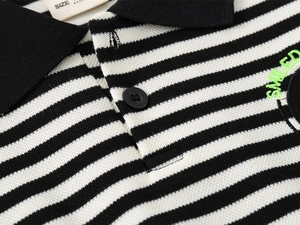 Detail of children's striped polo shirt with SMILED green embroidery and piqué fabric texture