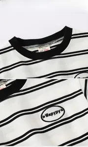Détail du col d'un t-shirt rayé pour enfant avec broderie et étiquette de taille