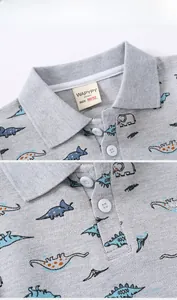Detail of grey cotton polo shirt showing piqué texture and cartoon dinosaur prints
