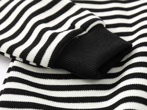 Detailed close-up of black and white striped knit fabric with ribbed cuffs for kids' shirts