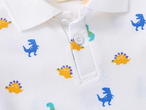 Detail of toddler white cotton polo shirt with colorful dinosaur print and classic collar