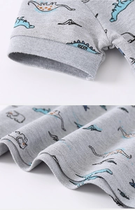 Detail of boys polo shirt ribbed cuff and dinosaur print on piqué cotton fabric