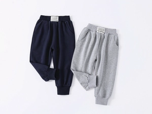Detail of kids cotton joggers featuring elastic waistband and FIND HAPPINESS patch label