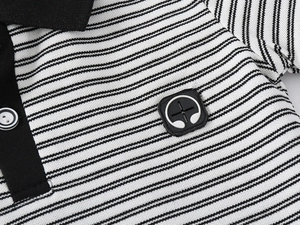 Détail du col d'un polo rayé pour enfant avec bordure contrastée et écusson casque