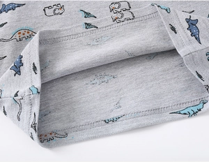 Close-up of boys gray pique polo shirt sleeve with colorful cartoon dinosaur prints