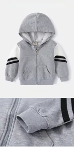 Détail du sweat à capuche gris garçon avec manches blanches contrastées et poignets rayés