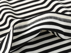 Macro shot of high-quality overlock stitching on black and white striped cotton fabric