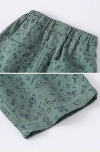 Detail of space-themed cotton shorts for boys with elastic waist and cosmic patterns