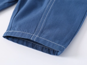 Close-up of boys' navy blue shorts featuring white contrast stitching and twill fabric texture