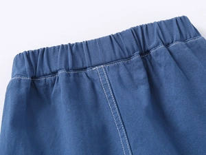 Detail of blue boys' shorts showing the elastic waistband and white stitch detailing