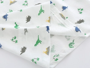 Detail of soft cotton kids t-shirt with colorful cartoon dinosaur and volcano prints