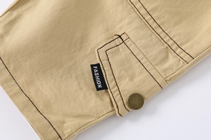 Detail of khaki boys cotton shorts showing cargo pocket with metal snap and fashion label