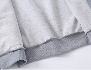 Détail d'un sweat gris pour garçon montrant le tissu bouclé et l'ourlet élastique côtelé
