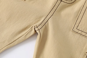 Detail shot of khaki shorts featuring contrast stitching and reinforced side pockets