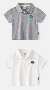 Close-up of children's cotton polo shirts with detailed cartoon dinosaur embroidery