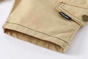 Detail of khaki cotton twill shorts featuring cargo pocket and fashion brand label