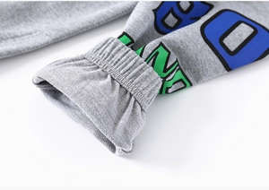 Détail du jogging gris pour enfants avec poignets élastiques et imprimés de lettres colorés