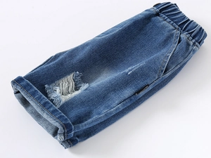 Detailed shot of boys blue distressed denim shorts with elastic waist and cuffed hems