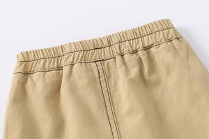 Close-up of boys khaki cotton shorts with elastic waistband and contrast stitching