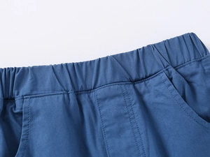 Detail of boys' navy blue cotton shorts featuring elastic waistband and precision stitching