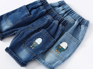 Detail of kids denim shorts showing elastic waist and cute robot cartoon on the pockets