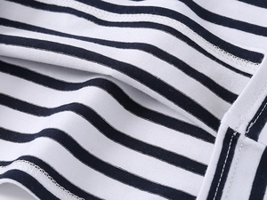 Dettaglio macro di cuciture di qualità e strisce bianche e nere su polo di cotone