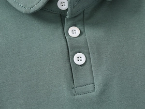 Close-up of sage green knit polo shirt showing fabric texture and three white buttons